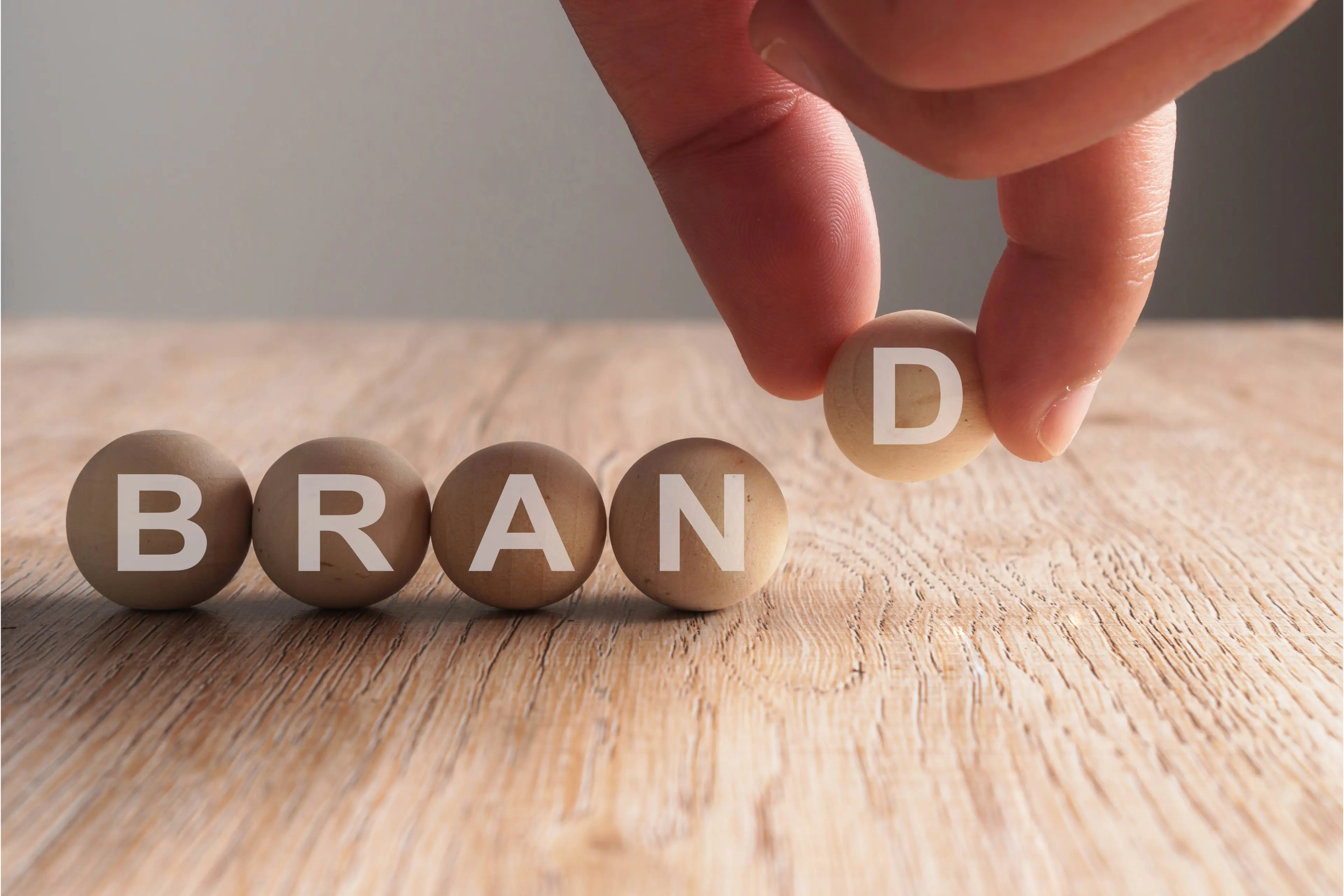 Hand putting on brand word written in wooden cube