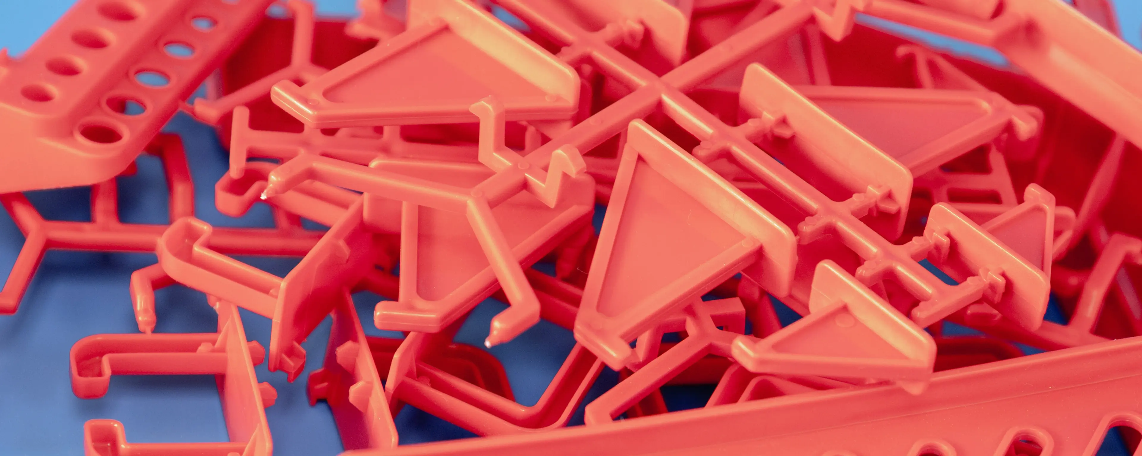 Assorted injection moulded plastic pieces on blue background