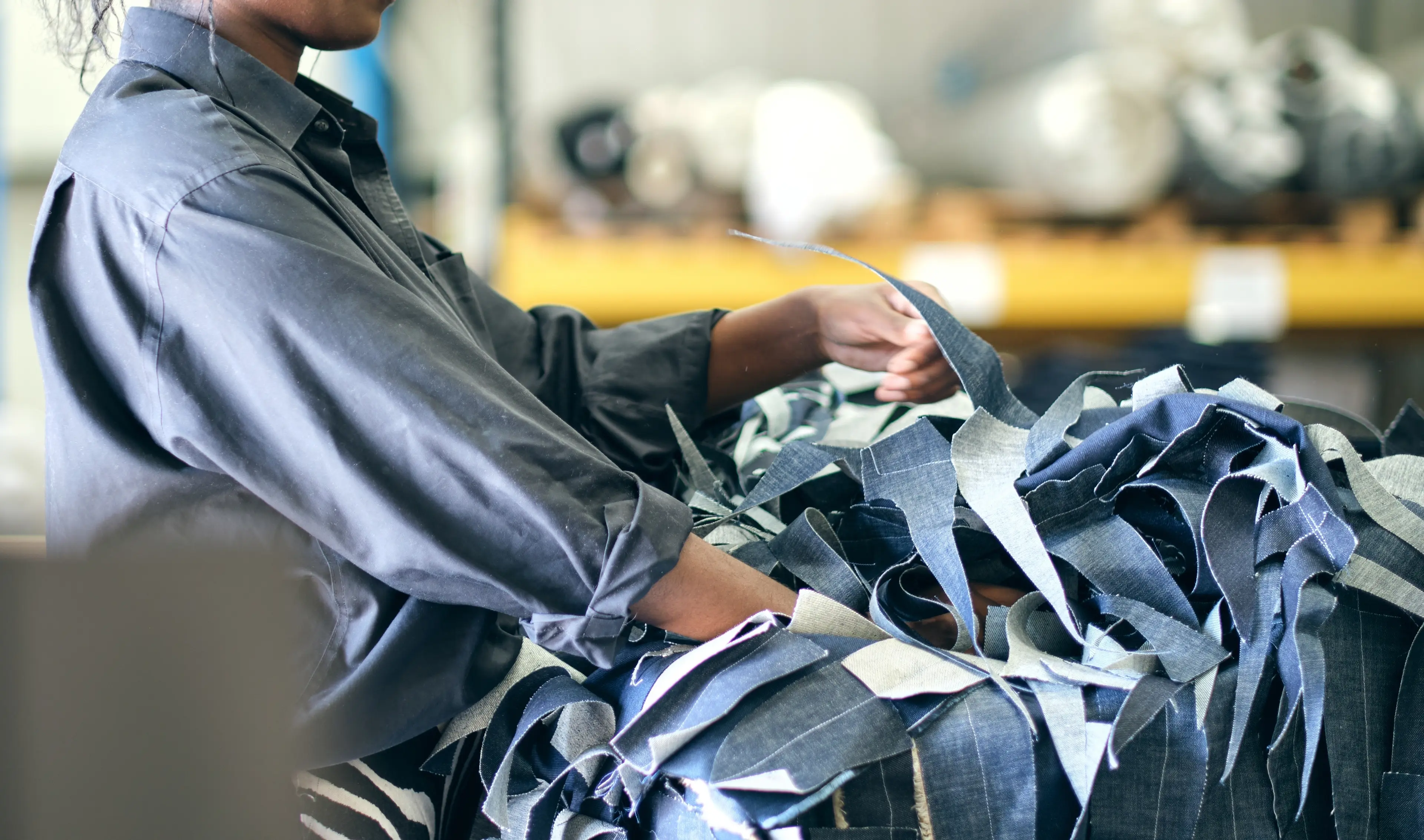 Person sorting pile of recycled denim