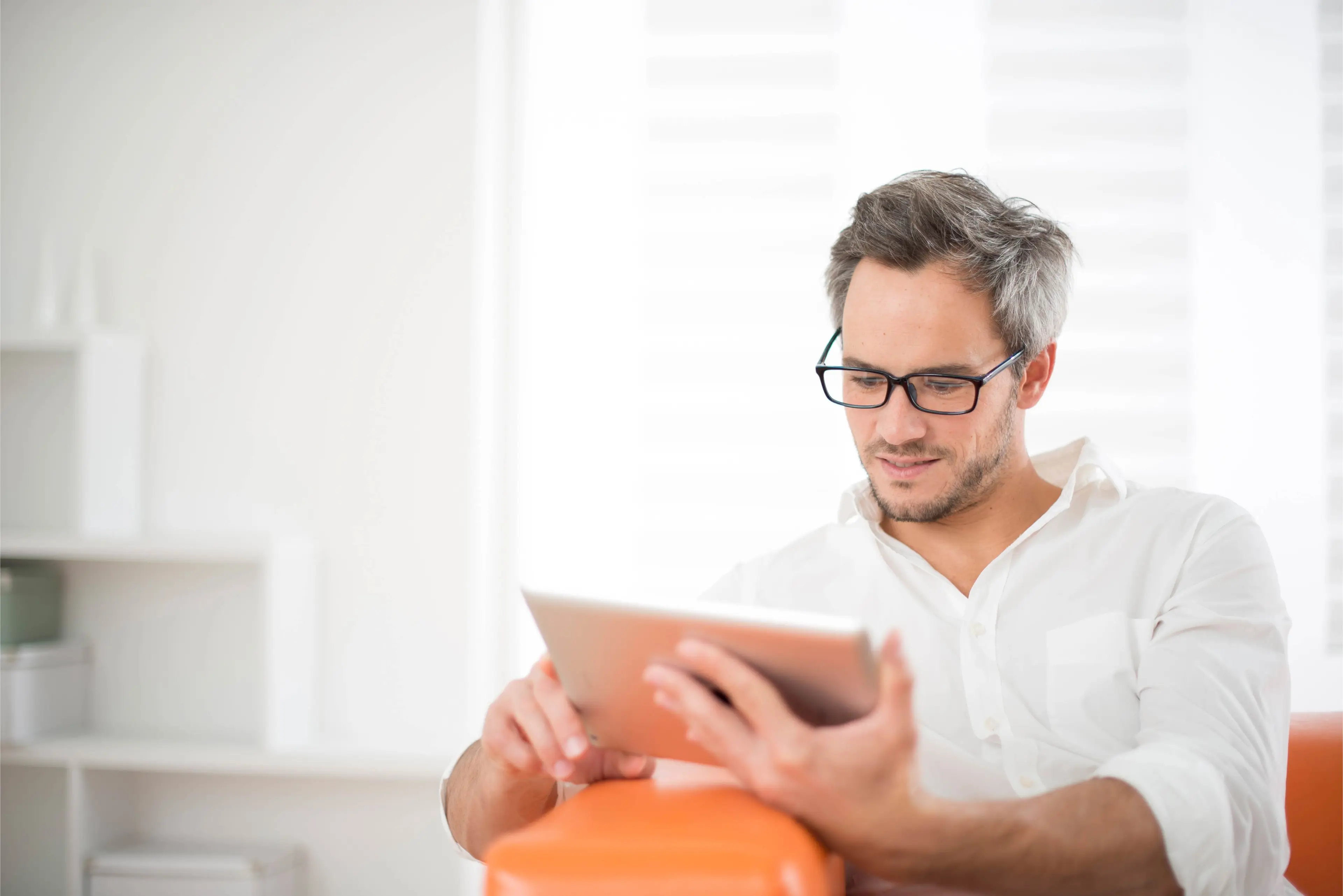 man wearing glasses holding an digital tablet